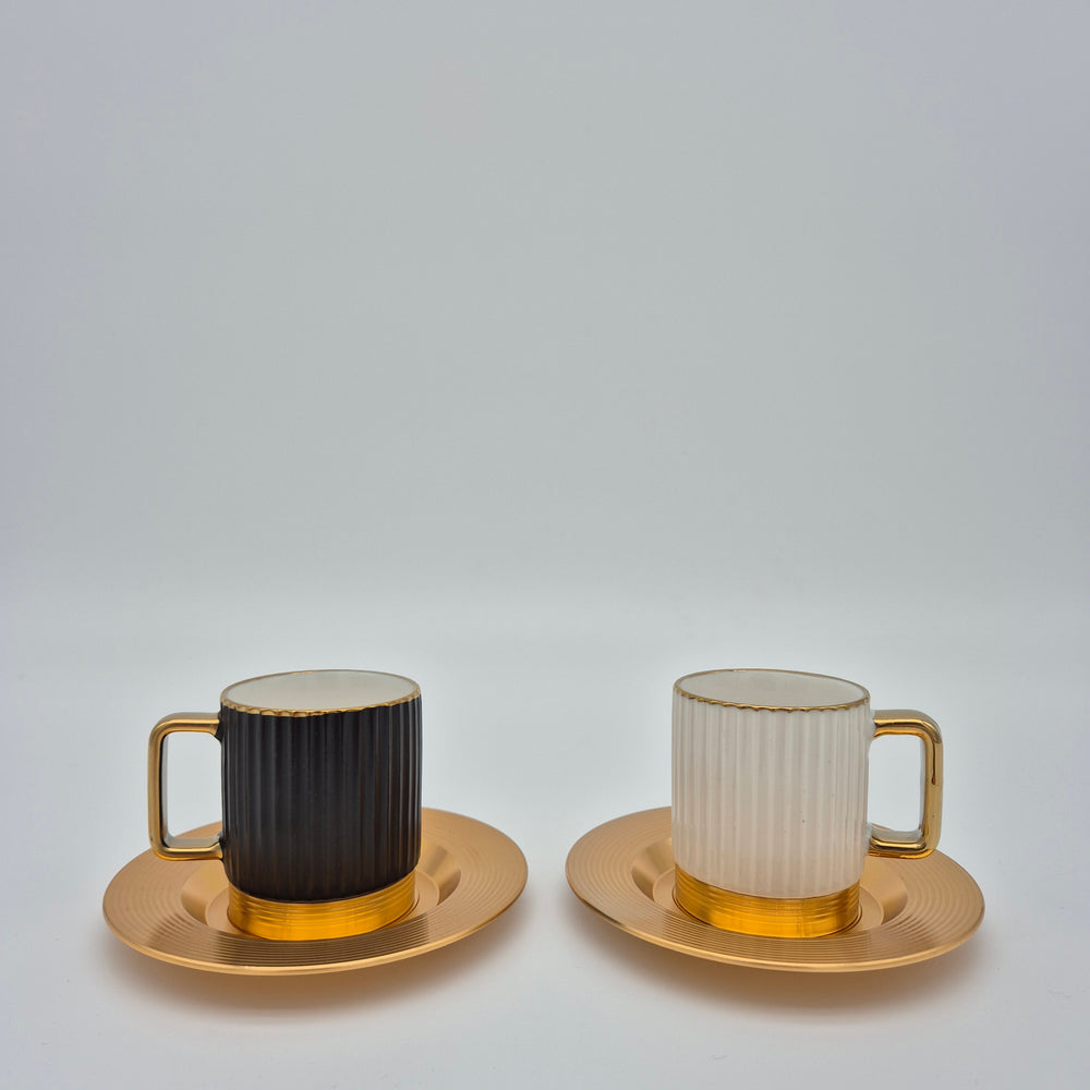 Tall black and white Eylul coffee cups with gold-coloured saucers